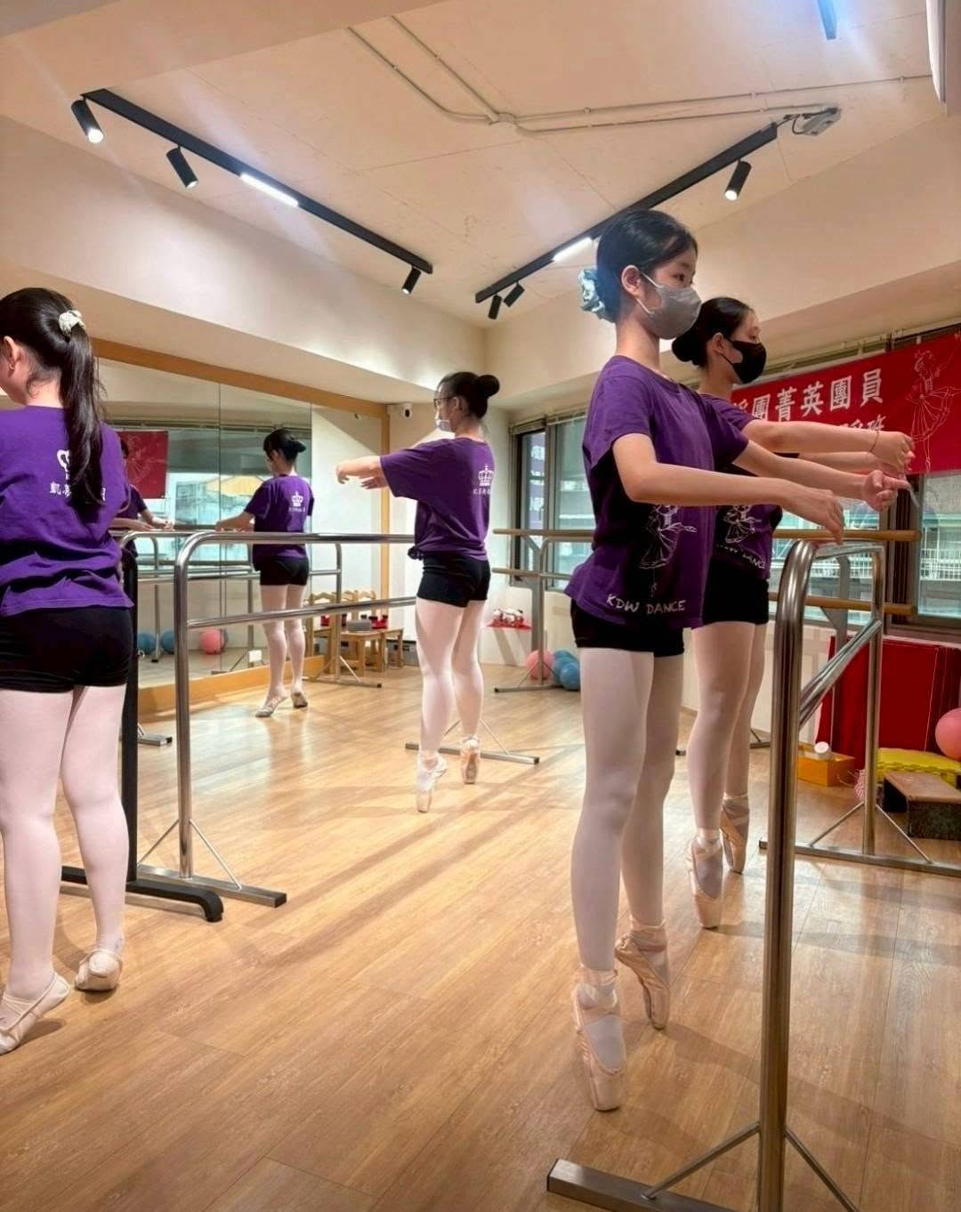 學員穿著足尖鞋在把桿旁練習